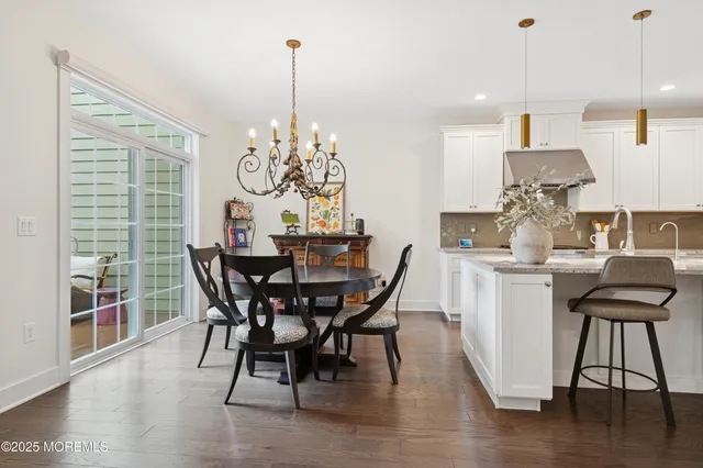a dining room with furniture a chandelier and wooden floor