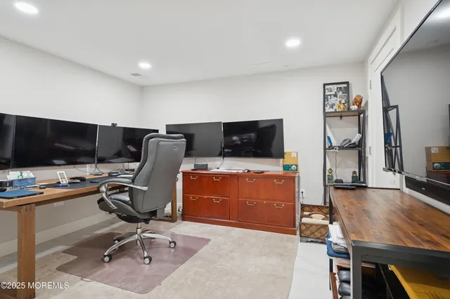 a view of a workspace with furniture and a flat screen tv