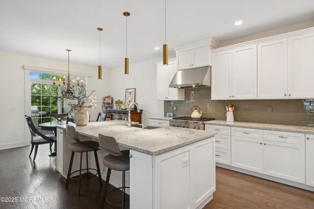 a kitchen with stainless steel appliances granite countertop a white cabinets and wooden floor