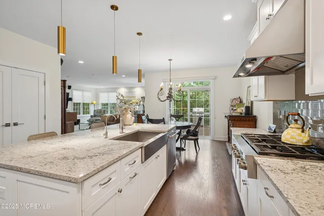 a kitchen with stainless steel appliances granite countertop a stove a sink and a wooden cabinets