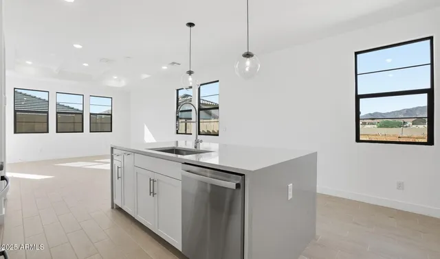 a kitchen with kitchen island a sink stainless steel appliances and cabinets