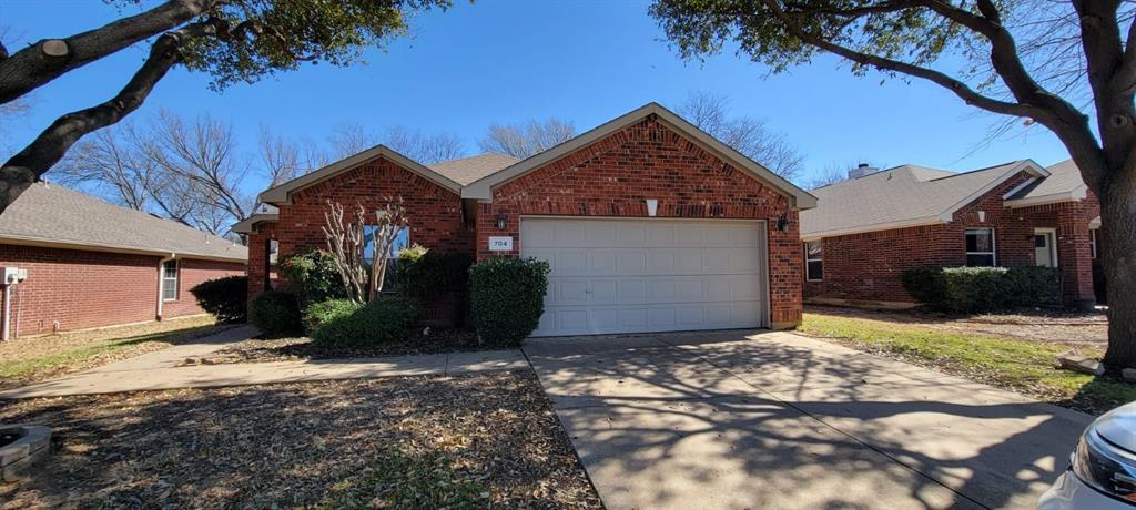 704 International Drive Euless, TX 76039 - Photo 1 of 1 View of front facade with an attached garage, brick siding, and driveway