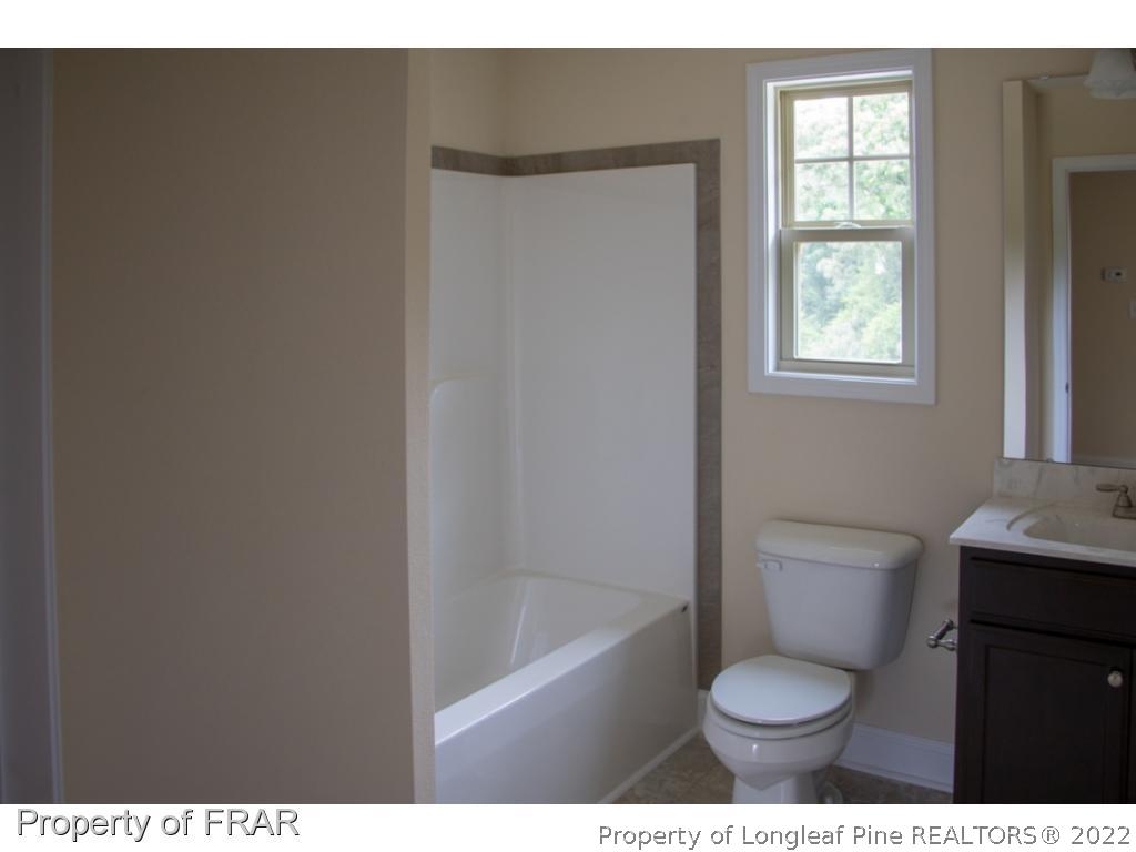 5219 Sunset View Road Hope Mills, NC 28348 - Photo 17 of 24 a bathroom with a toilet a sink and a bathtub