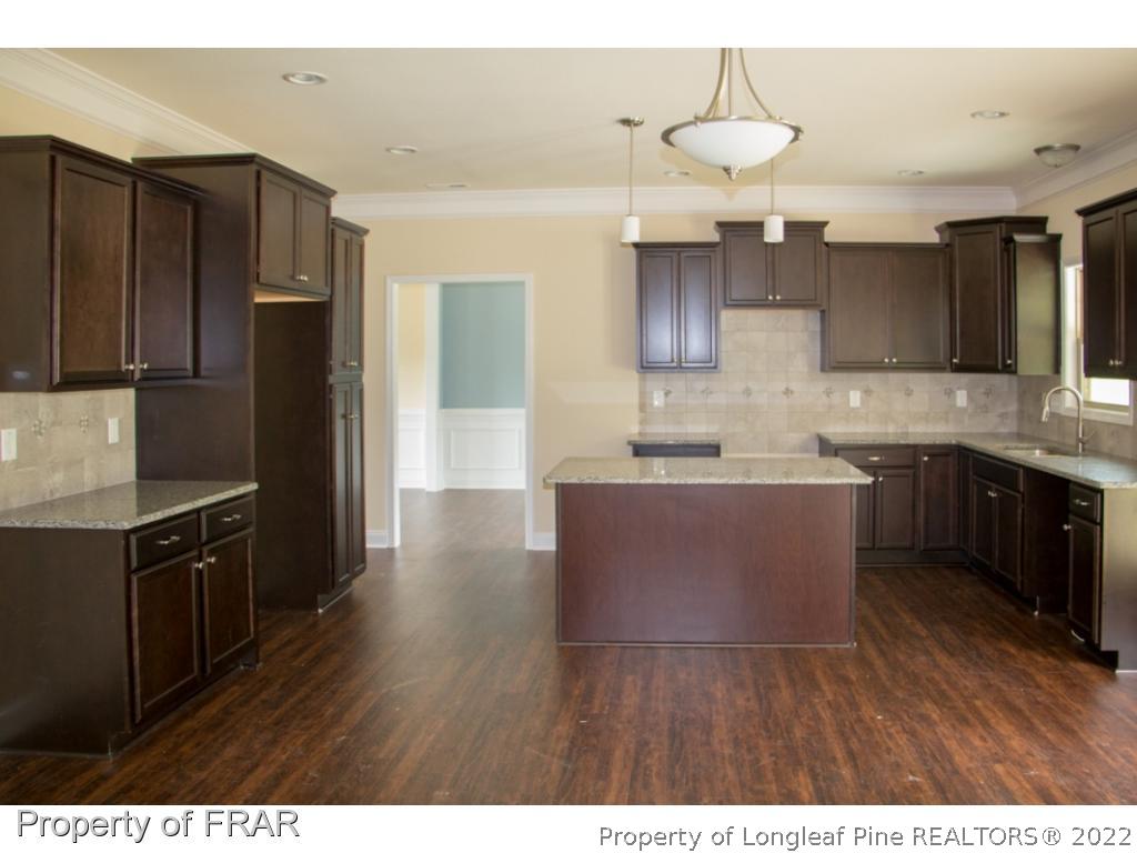5219 Sunset View Road Hope Mills, NC 28348 - Photo 8 of 24 a kitchen with stainless steel appliances granite countertop a refrigerator a sink dishwasher a stove and white countertops with wooden floor