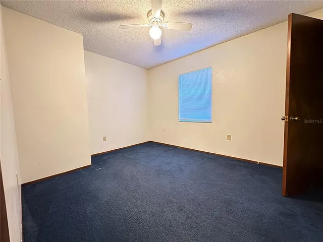an empty room with a ceiling fan and a window