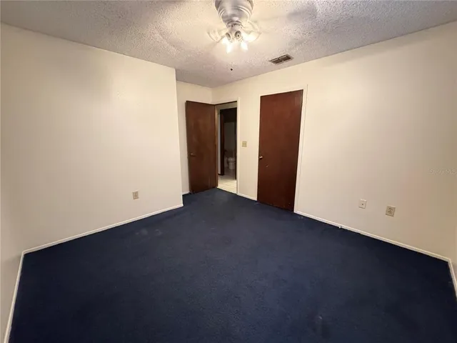 an empty room with a ceiling fan and a window