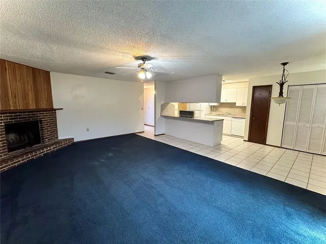 a view of a kitchen with a sink dishwasher and a fireplace
