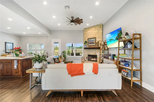 a living room with fireplace furniture and a kitchen view