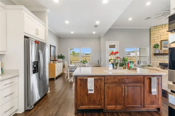 a kitchen with kitchen island granite countertop wooden floors and stainless steel appliances