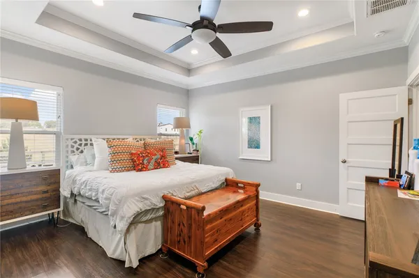 a bedroom with a bed chandelier and a window