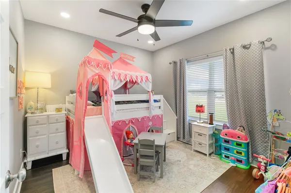 a bedroom with furniture and a fan