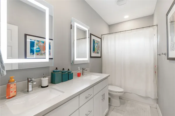 a bathroom with a granite countertop sink mirror vanity and toilet