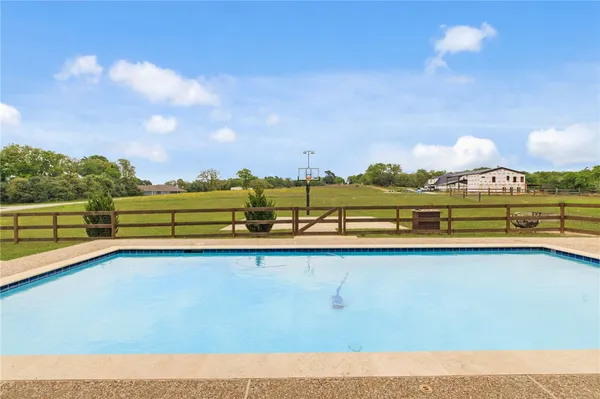 a view of swimming pool with lake and houses in the back