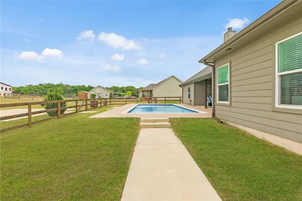 a view of swimming pool of the house with a yard