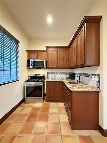 12410 Keith Road Beaumont, TX 77713 - Photo 17 of 45 a kitchen with stainless steel appliances granite countertop a stove a sink dishwasher and a refrigerator with wooden cabinets