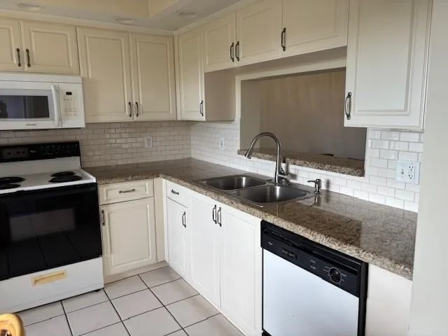 a kitchen with granite countertop a sink and a stove
