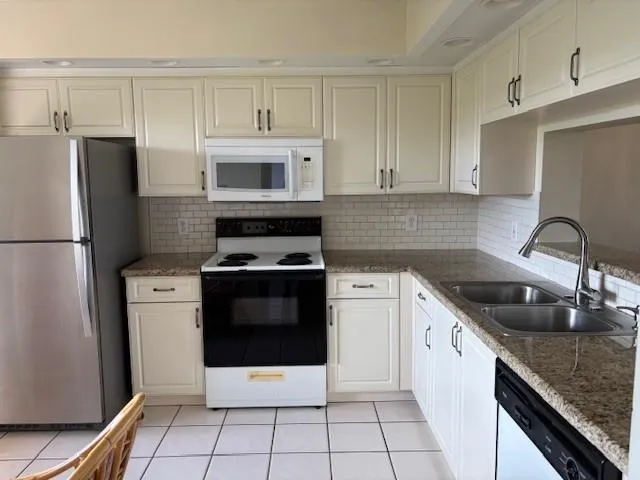 a kitchen with granite countertop a sink and cabinets