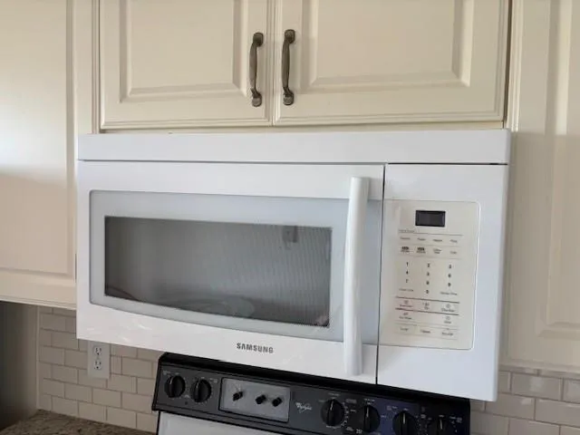 a kitchen with stainless steel appliances granite countertop a refrigerator a stove a sink and a microwave