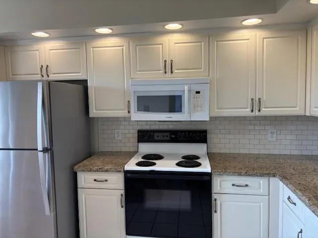 a kitchen with stainless steel appliances granite countertop a stove a refrigerator and a sink