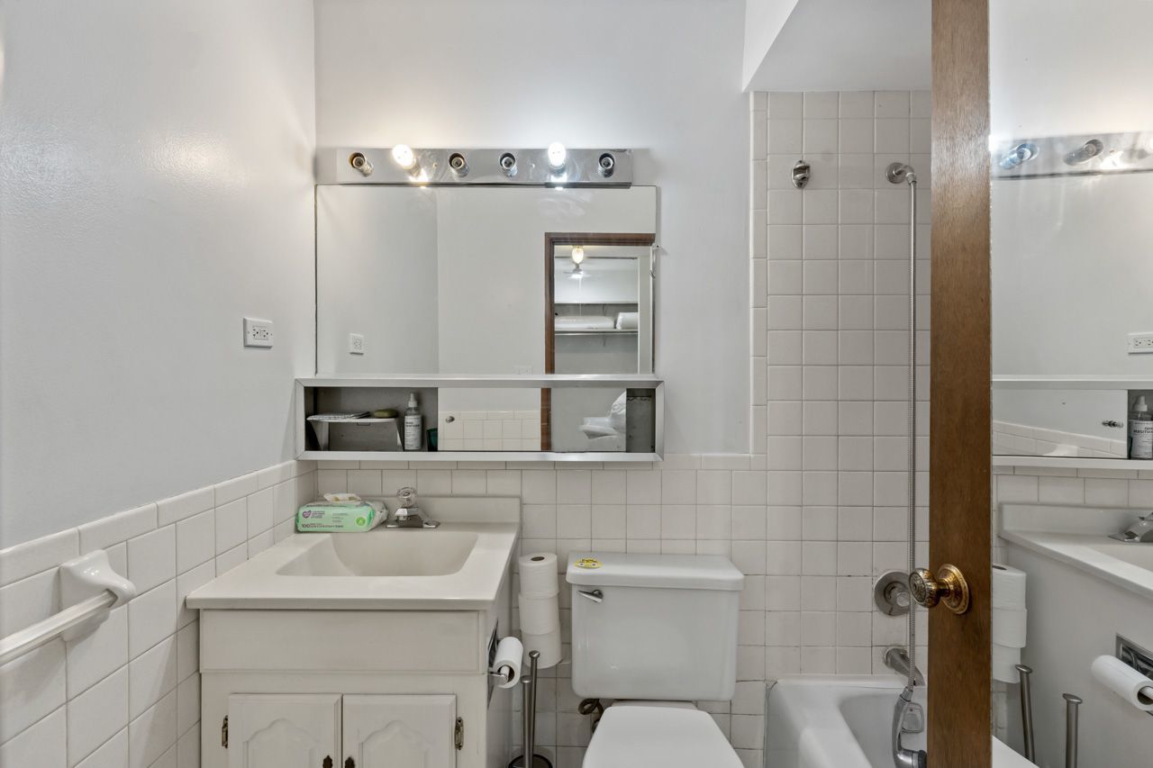 4623 North Chester Avenue, Unit 206 Chicago, IL 60656 - Photo 11 of 19 a bathroom with a sink a toilet and mirror