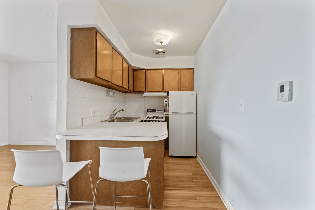 4623 North Chester Avenue, Unit 206 Chicago, IL 60656 - Photo 3 of 19 a kitchen with stainless steel appliances granite countertop a refrigerator a stove a sink and a dining table with wooden floor