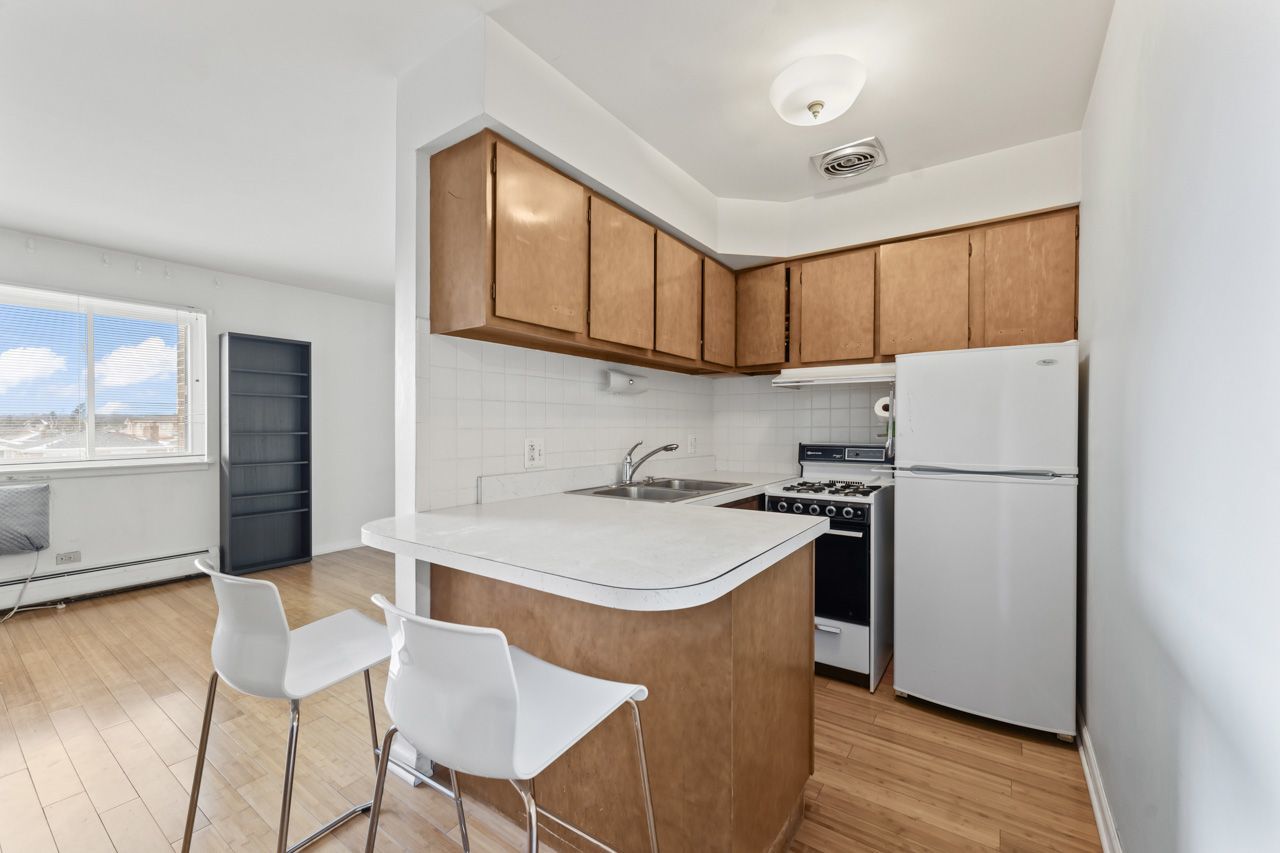 4623 North Chester Avenue, Unit 206 Chicago, IL 60656 - Photo 4 of 19 a kitchen with a refrigerator a stove a sink and chairs
