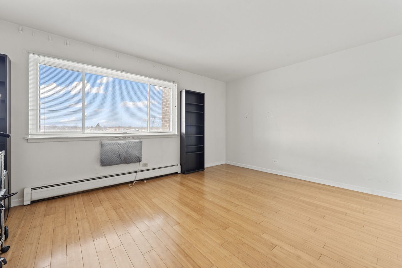 4623 North Chester Avenue, Unit 206 Chicago, IL 60656 - Photo 7 of 19 an empty room with wooden floor and windows