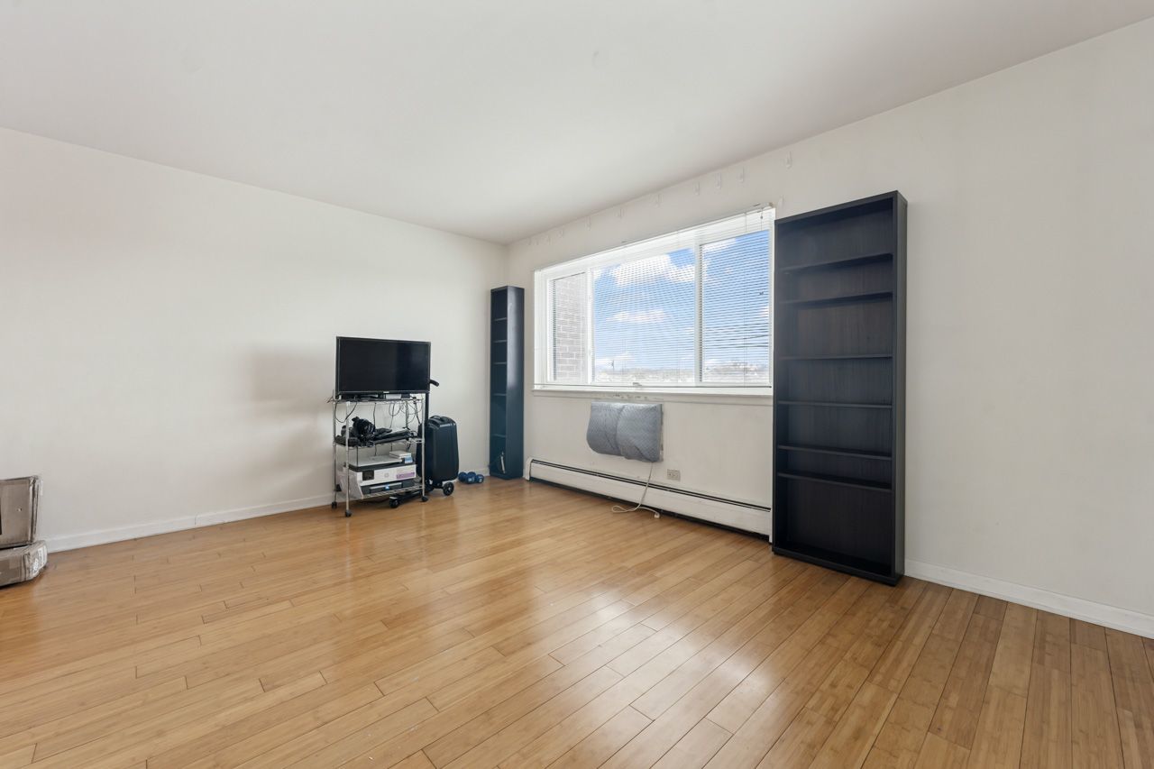 4623 North Chester Avenue, Unit 206 Chicago, IL 60656 - Photo 10 of 19 an empty room with a wooden floor and a window