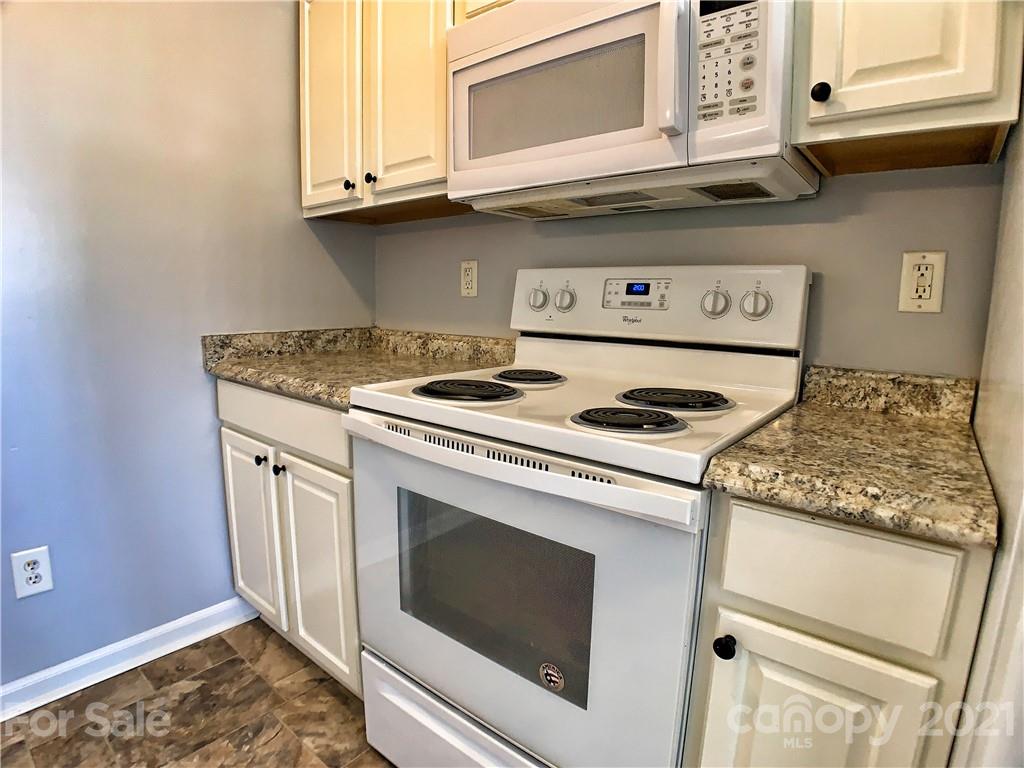 1524 Capps Hill Mine Road Charlotte, NC 28216 - Photo 15 of 32 a kitchen with stainless steel appliances granite countertop a stove and a microwave