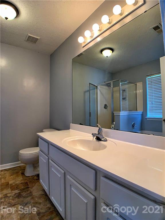 1524 Capps Hill Mine Road Charlotte, NC 28216 - Photo 22 of 32 a bathroom with a sink a toilet and mirror