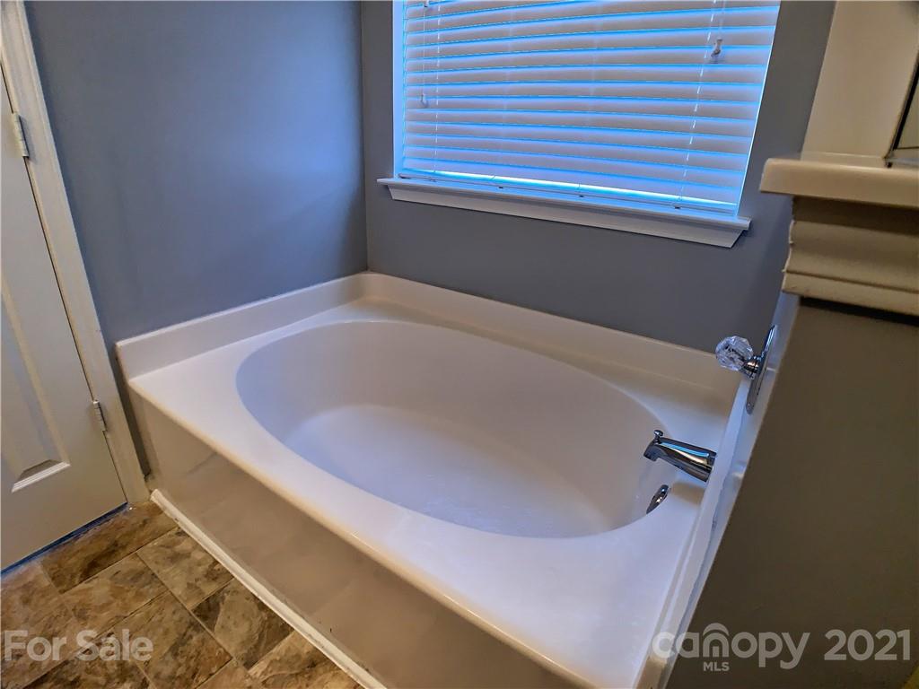 1524 Capps Hill Mine Road Charlotte, NC 28216 - Photo 24 of 32 a bath tub sitting in a bathroom next to a blue sink