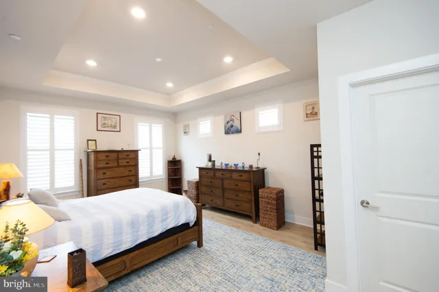 a spacious bedroom with a bed and wooden floor