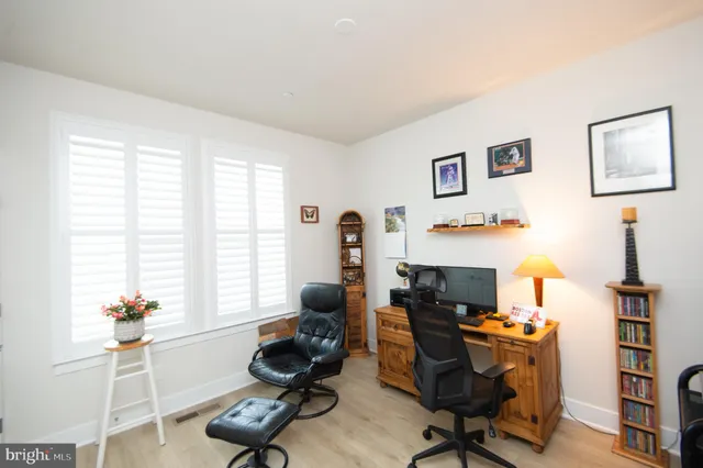 a view of a workspace with furniture and a window