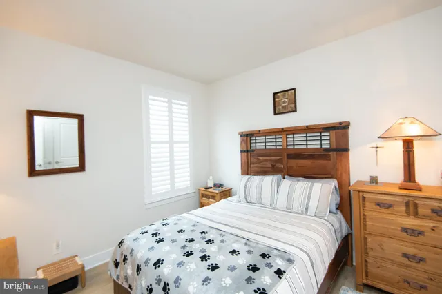 a bedroom with a bed and a lamp on dresser