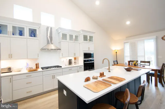 a open dining room with stainless steel appliances kitchen island granite countertop a dining table and chairs