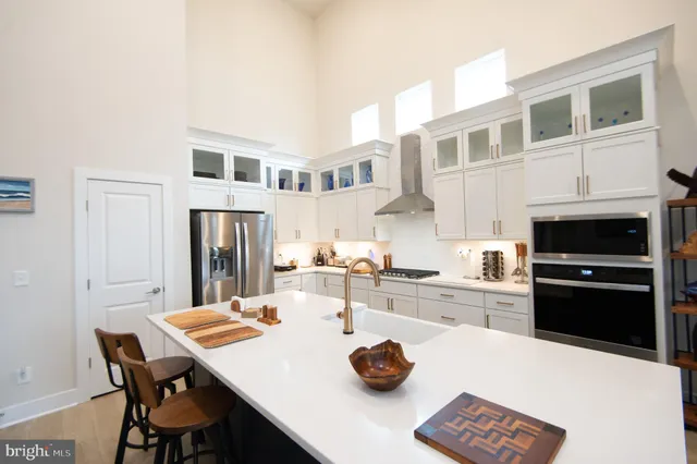 a kitchen with stainless steel appliances kitchen island granite countertop a dining table and chairs with wooden floor