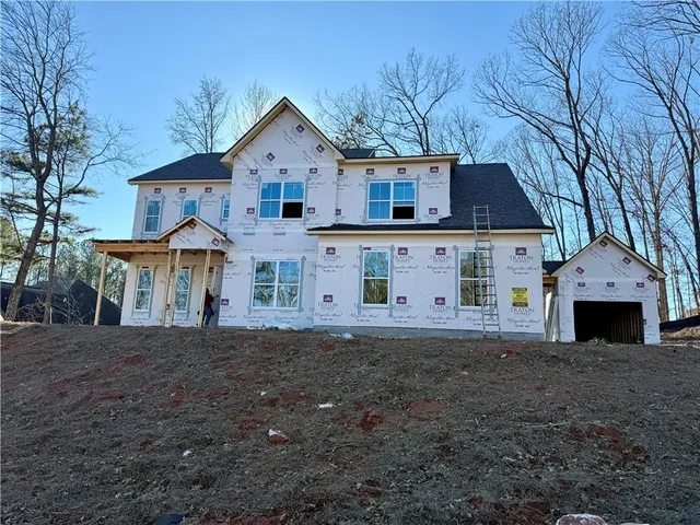 a view of a yard in front of a house with large windows