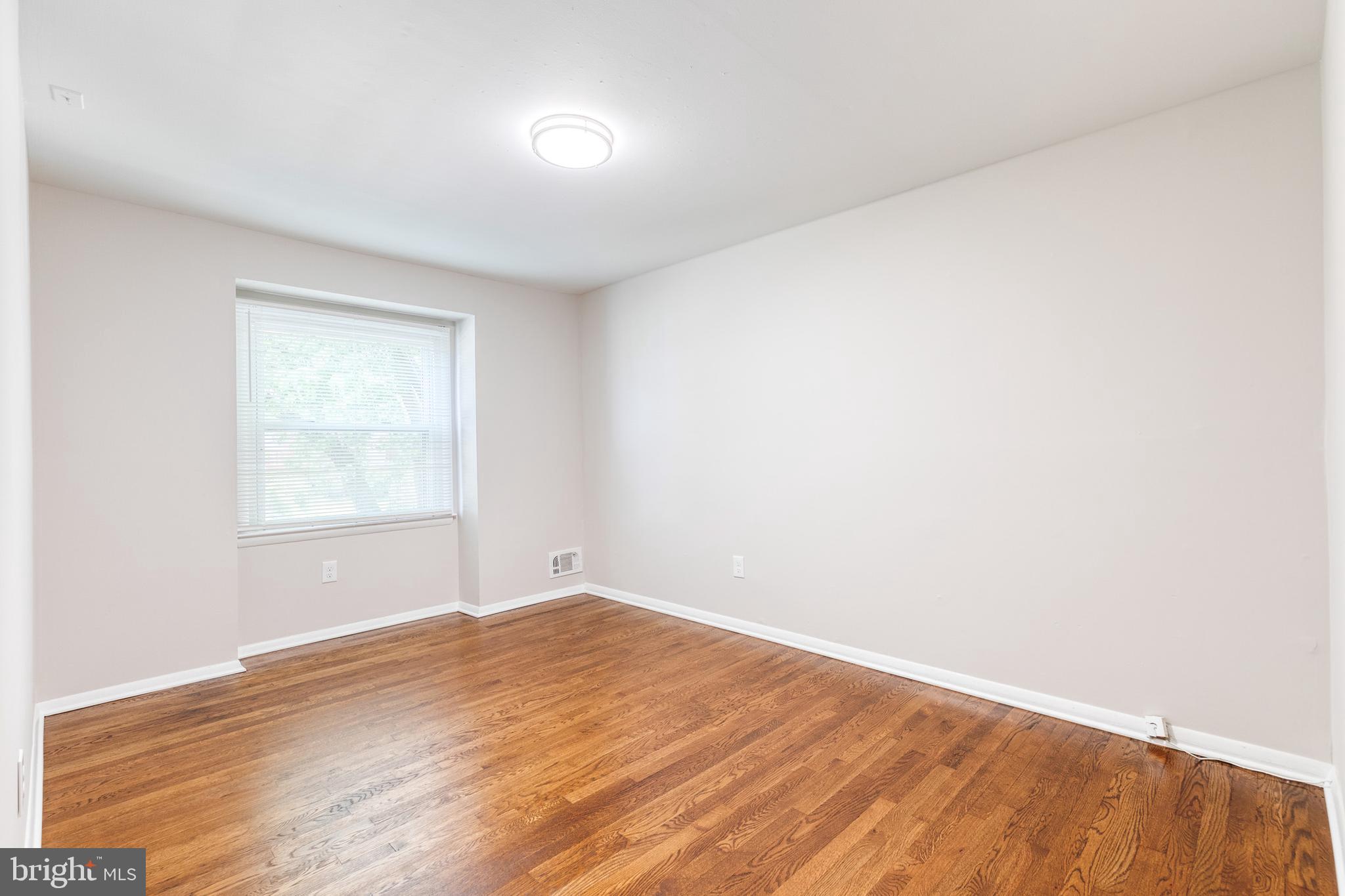 5649 Utrecht Road Baltimore, MD 21206 - Photo 28 of 42 an empty room with wooden floor and windows