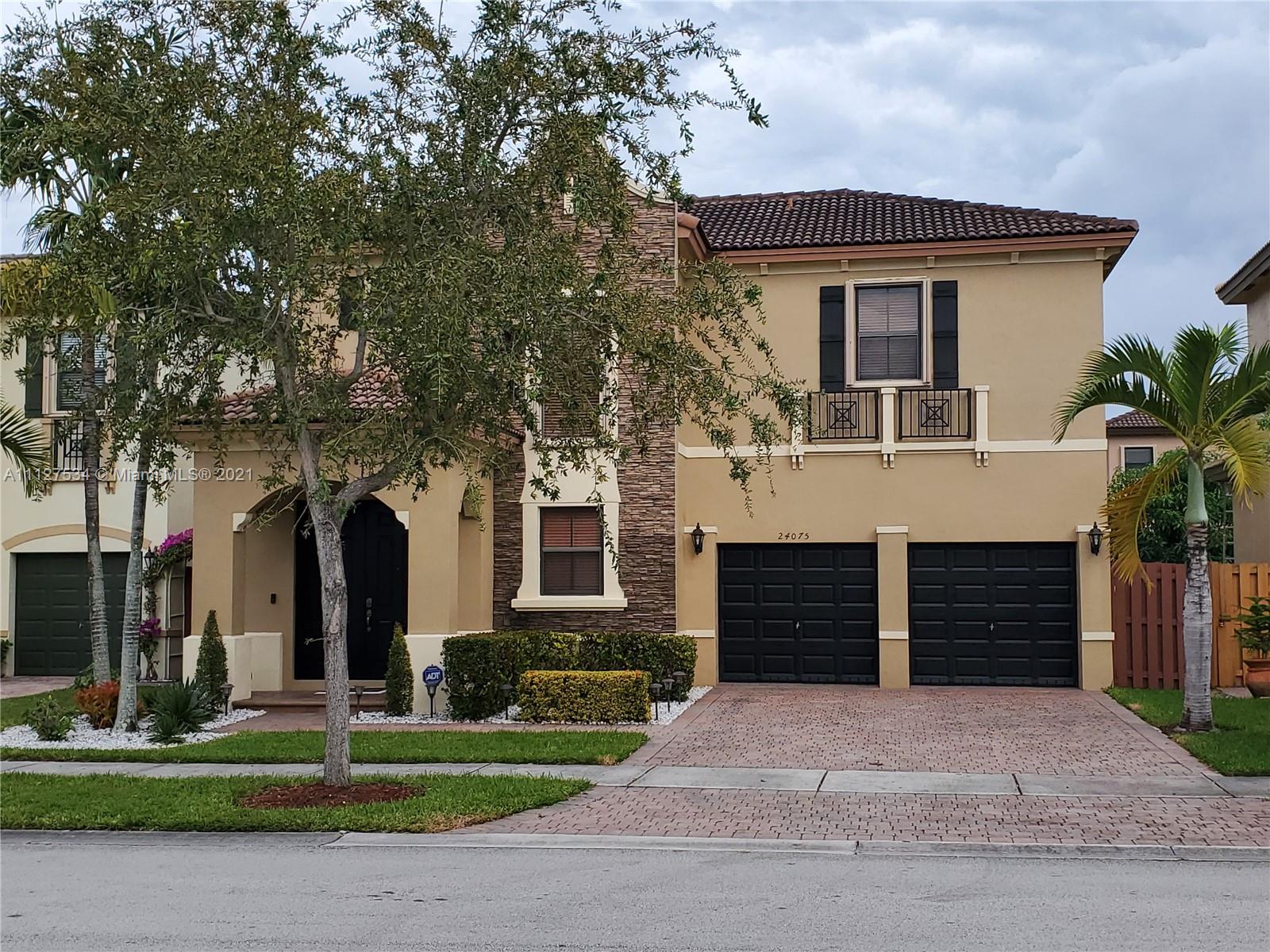 24075 Southwest 113 Passage Homestead, FL 33032 - Photo 1 of 35 a front view of a house with a yard and garage