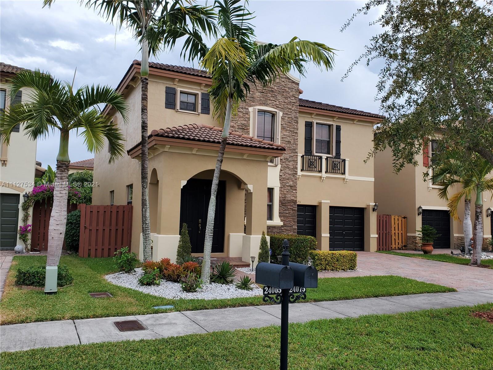 24075 Southwest 113 Passage Homestead, FL 33032 - Photo 2 of 35 a front view of house with yard and green space