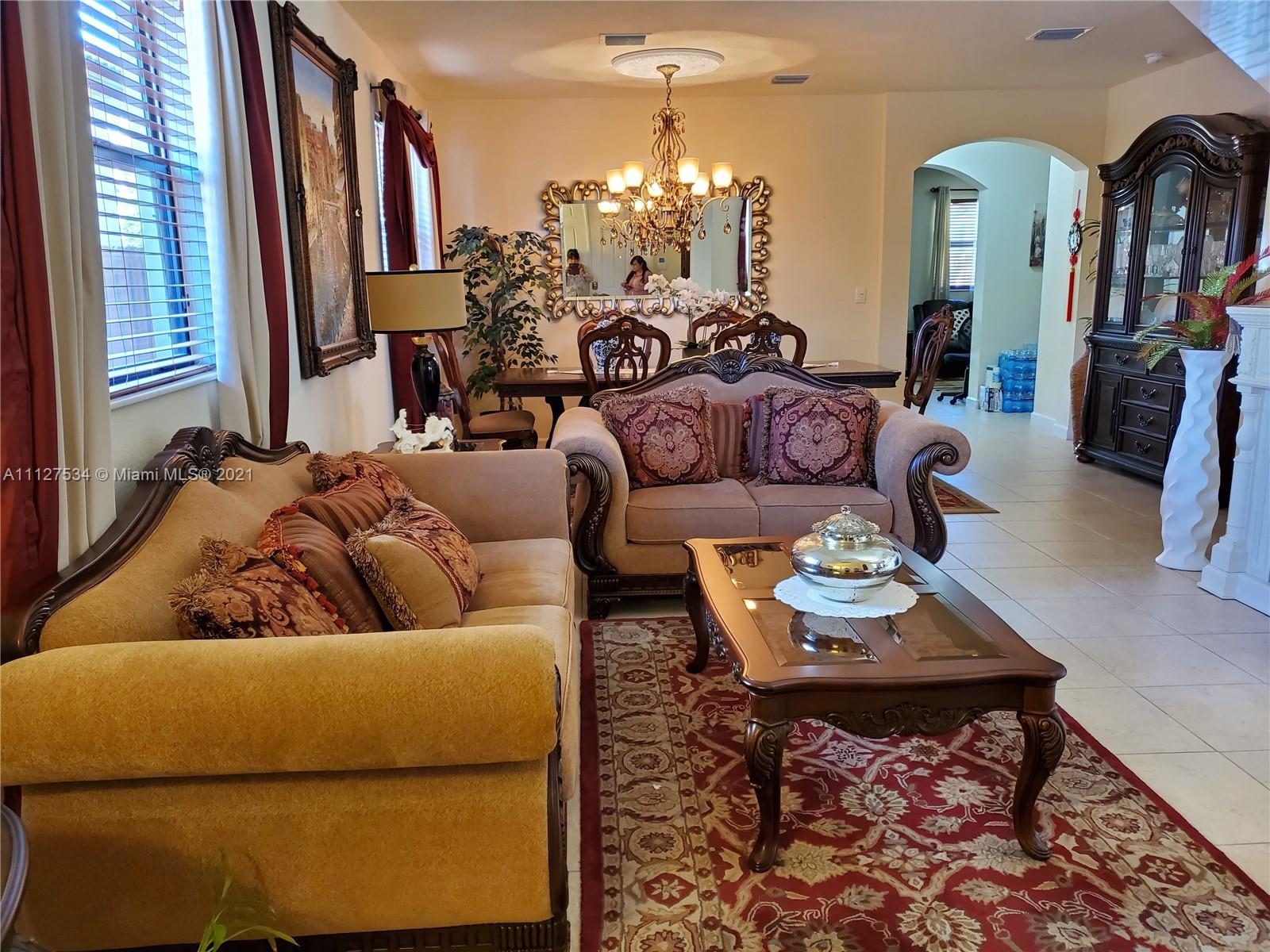24075 Southwest 113 Passage Homestead, FL 33032 - Photo 15 of 35 a living room with furniture and a chandelier
