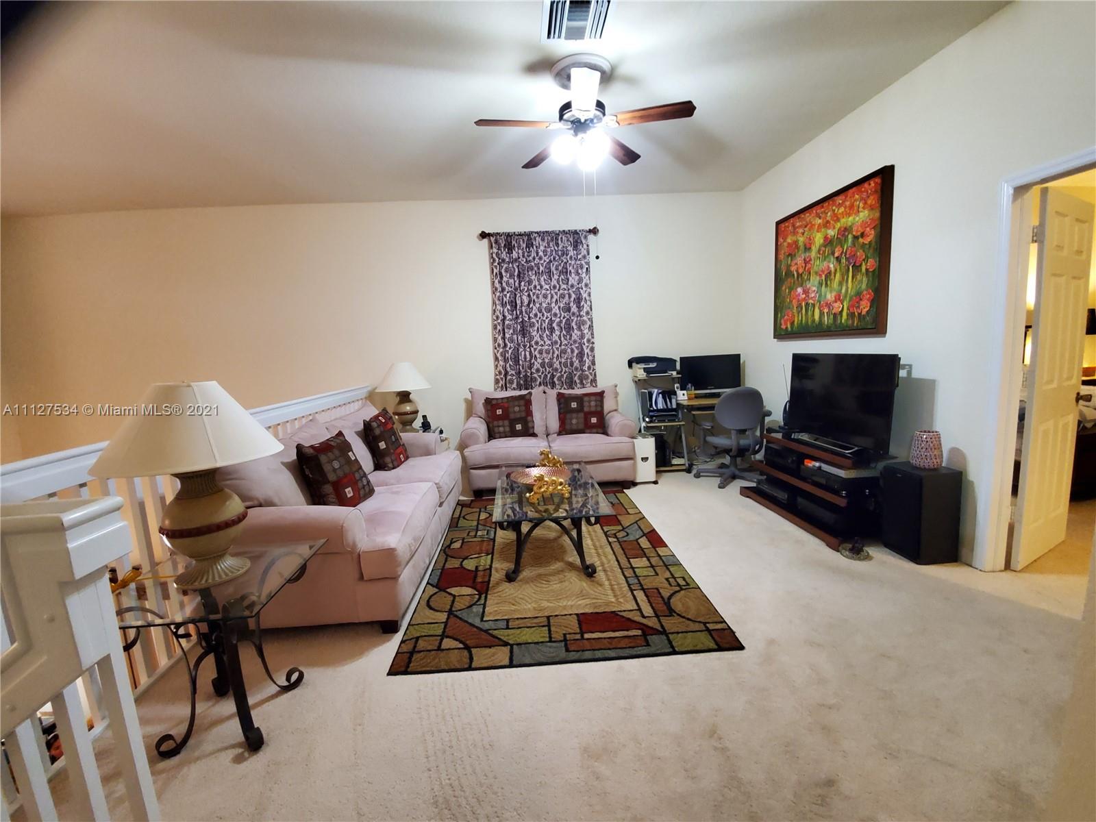 24075 Southwest 113 Passage Homestead, FL 33032 - Photo 22 of 35 a living room with furniture and a flat screen tv