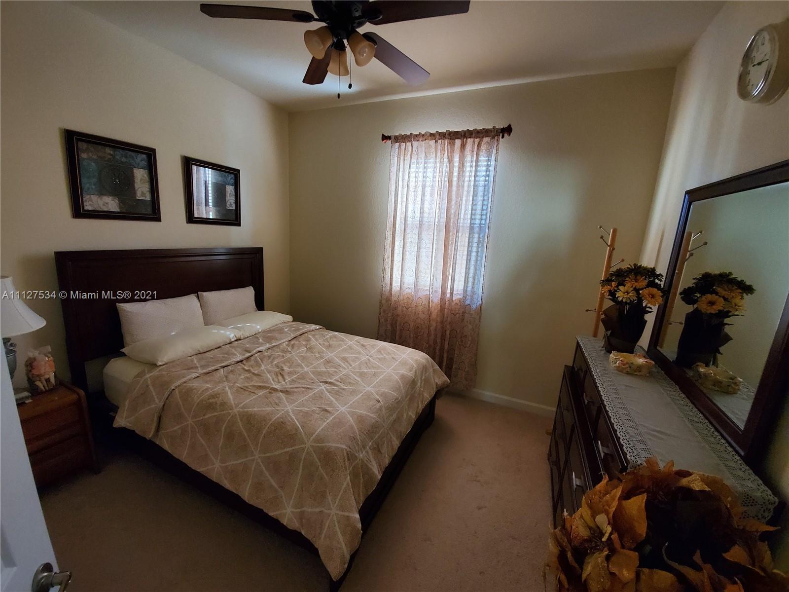 24075 Southwest 113 Passage Homestead, FL 33032 - Photo 27 of 35 a bedroom with a bed and a chandelier