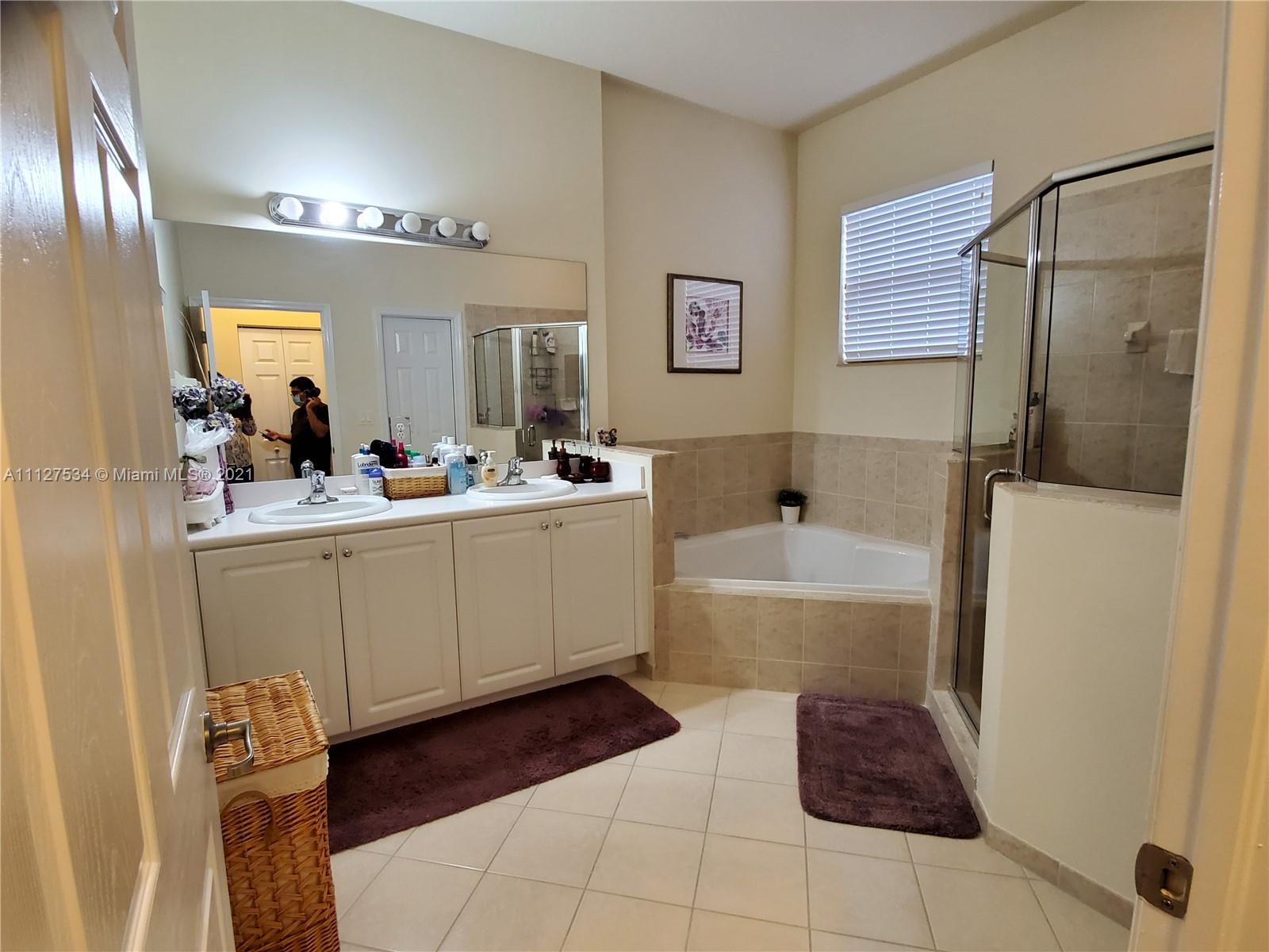 24075 Southwest 113 Passage Homestead, FL 33032 - Photo 28 of 35 a bathroom with a tub sink and mirror