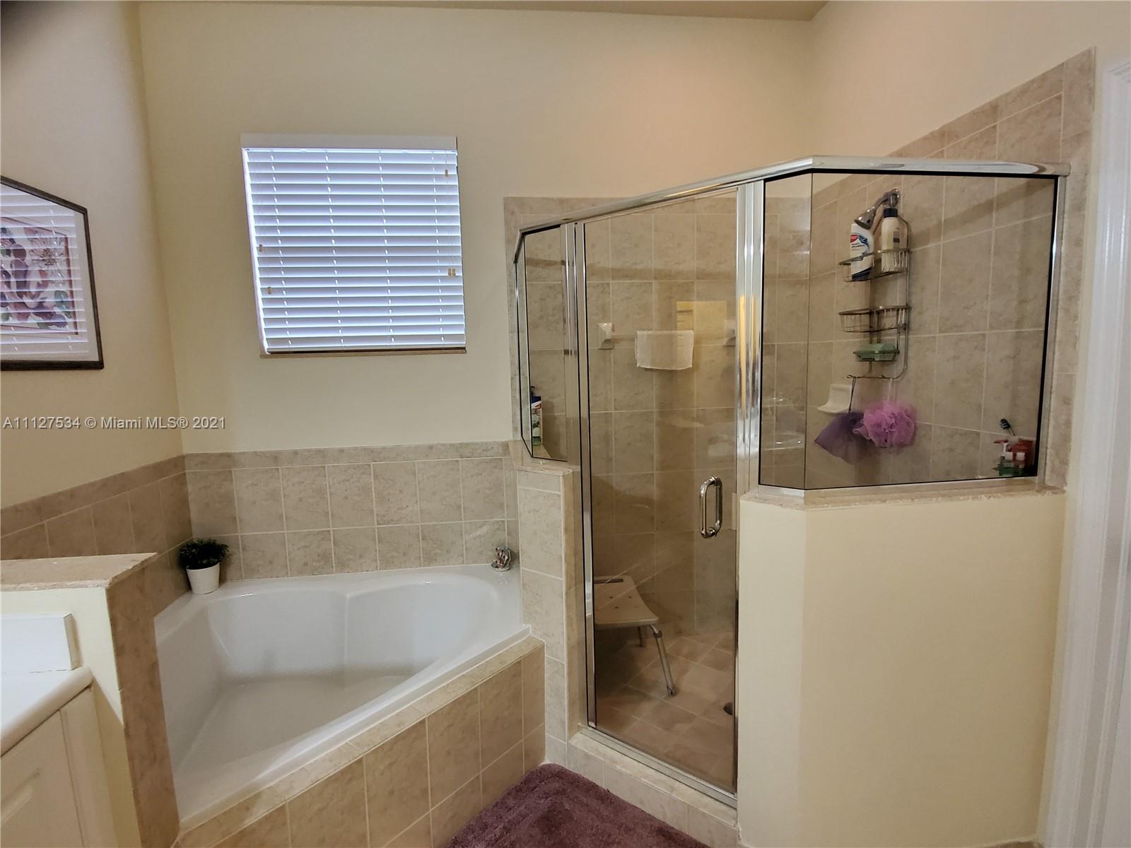 24075 Southwest 113 Passage Homestead, FL 33032 - Photo 29 of 35 a bathroom with a tub and shower