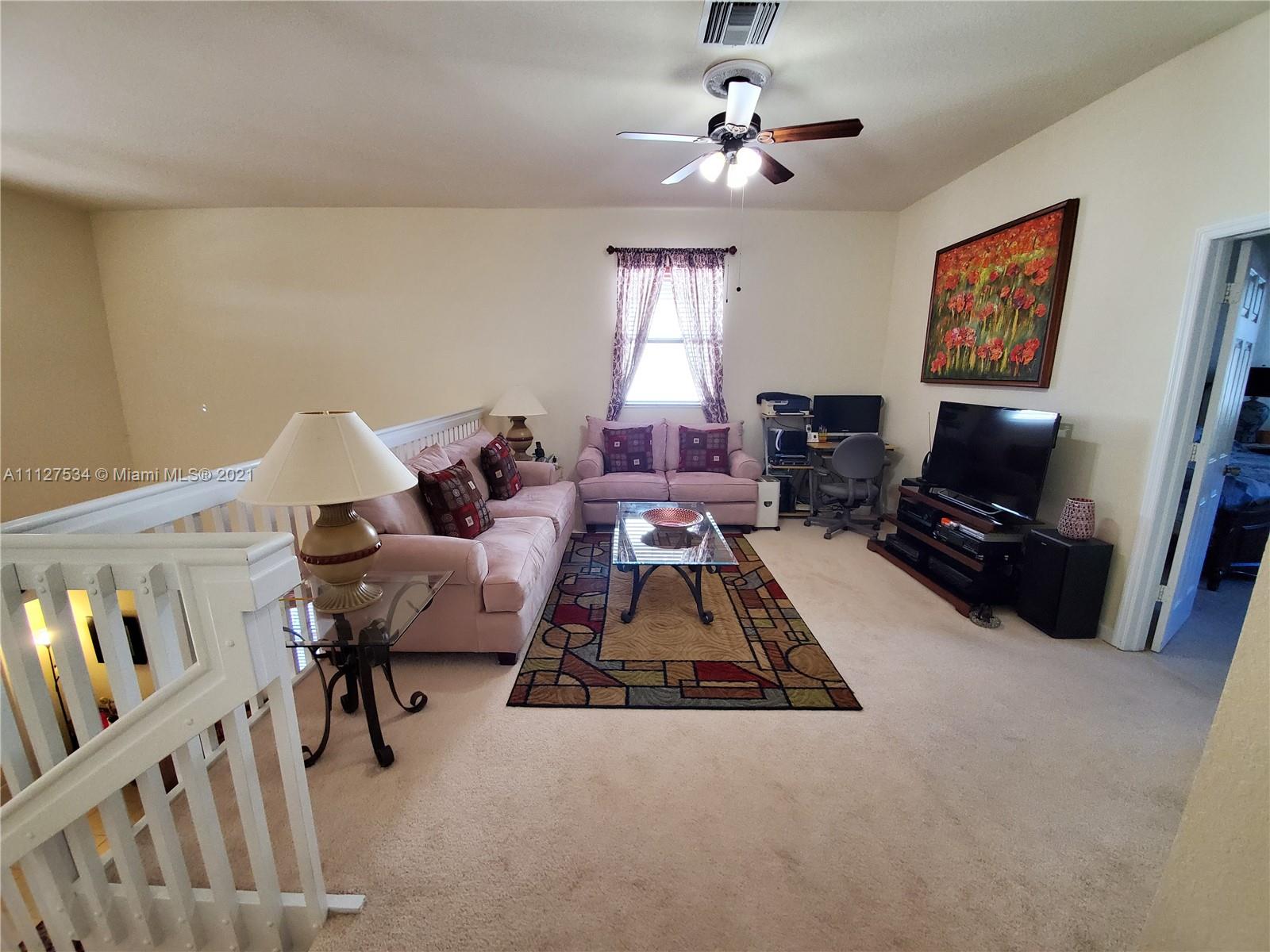24075 Southwest 113 Passage Homestead, FL 33032 - Photo 10 of 35 a living room with furniture and a flat screen tv