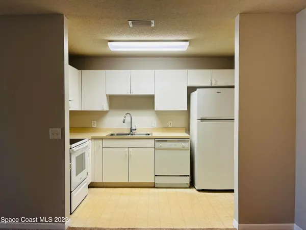 a kitchen with a sink a refrigerator and cabinets
