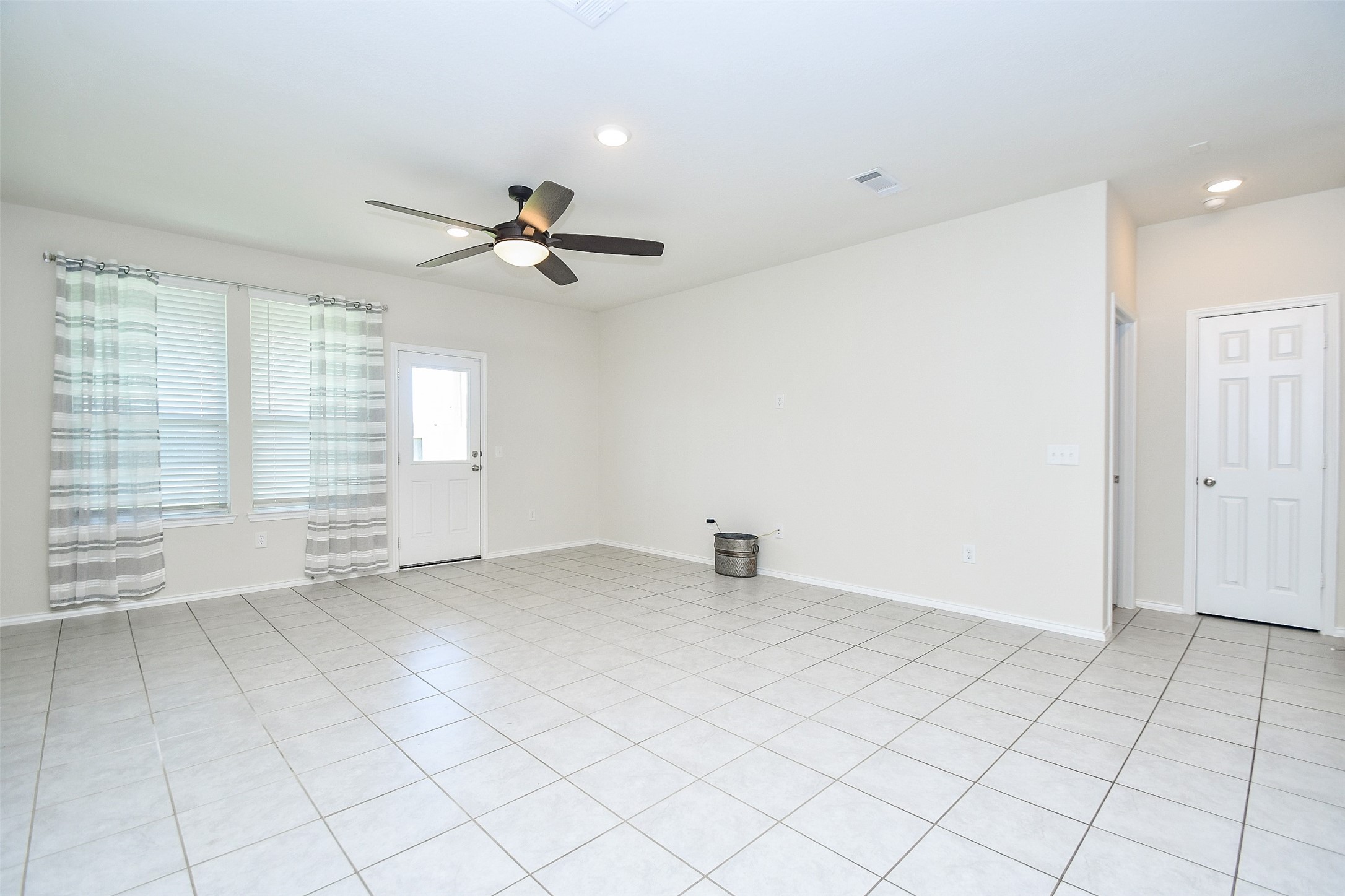 25918 Rustical Road Katy, TX 77493 - Photo 17 of 26 an empty room with chandelier fan and windows