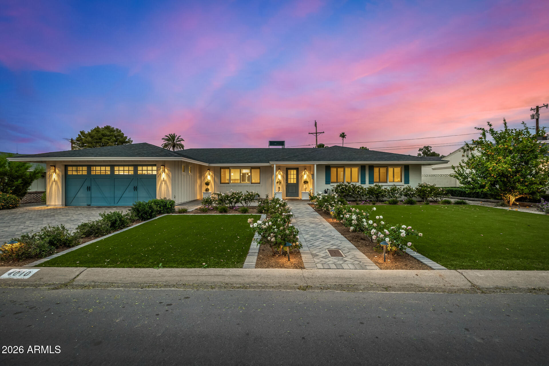 a front view of a house with a yard and potted plants