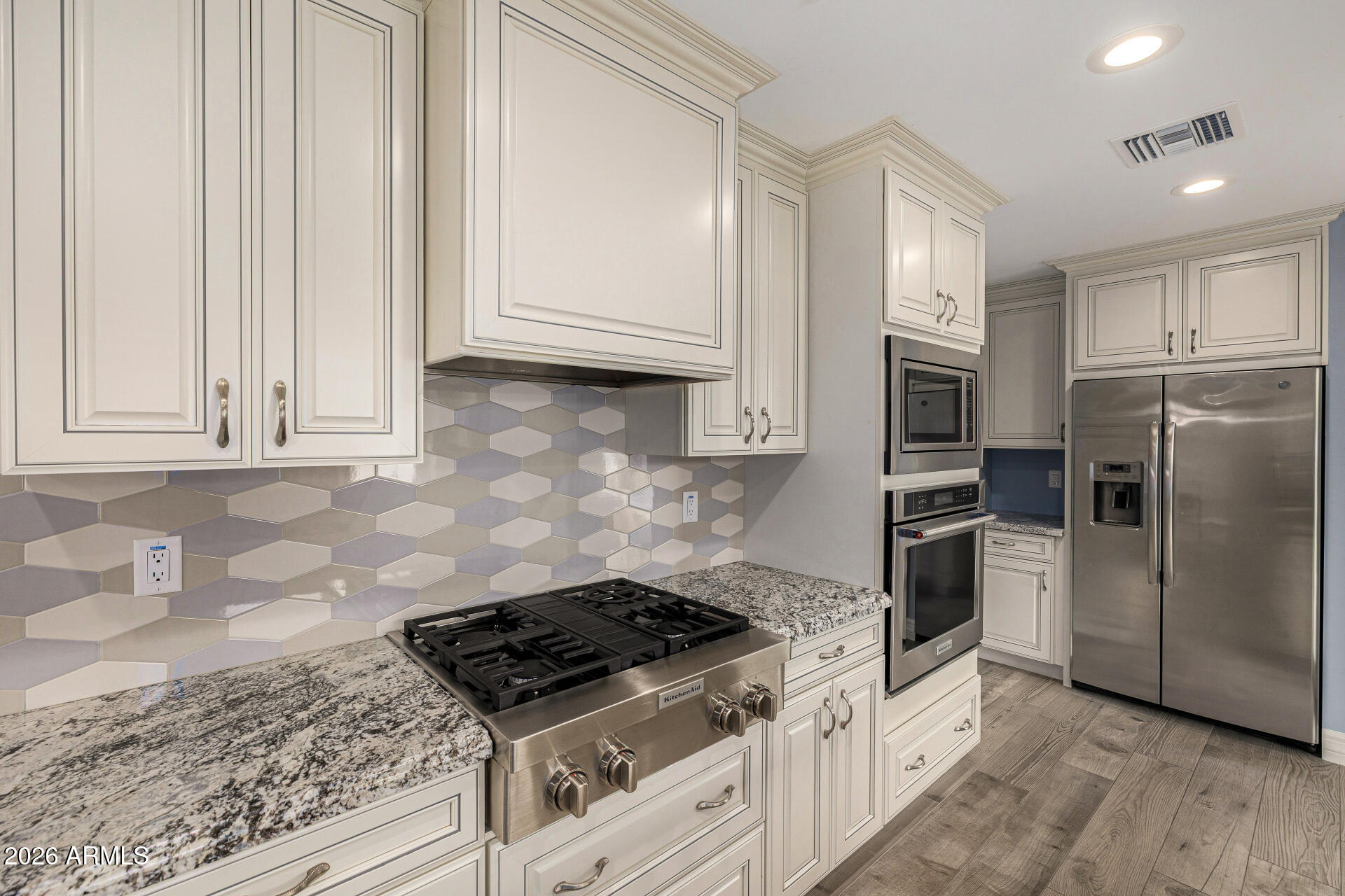 4010 East Coolidge Street Phoenix, AZ 85018 - Photo 27 of 82 a kitchen with granite countertop white cabinets and stainless steel appliances